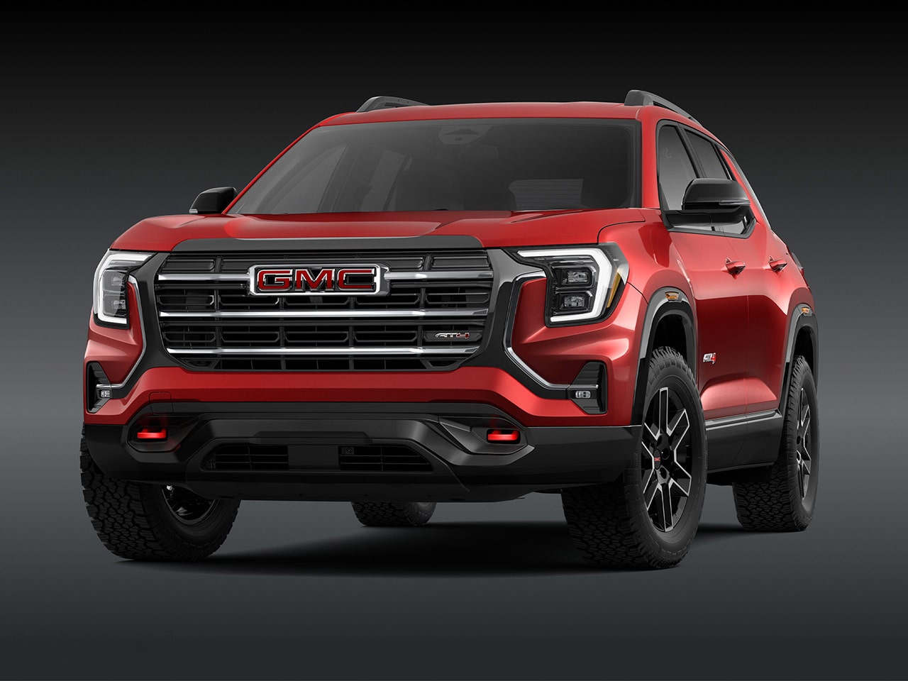 Une vue extérieure frontale d’un SUV AT4 AT4 GMC Terrain rouge 2027 avec une calandre proéminente, des phares et des pneus robustes.