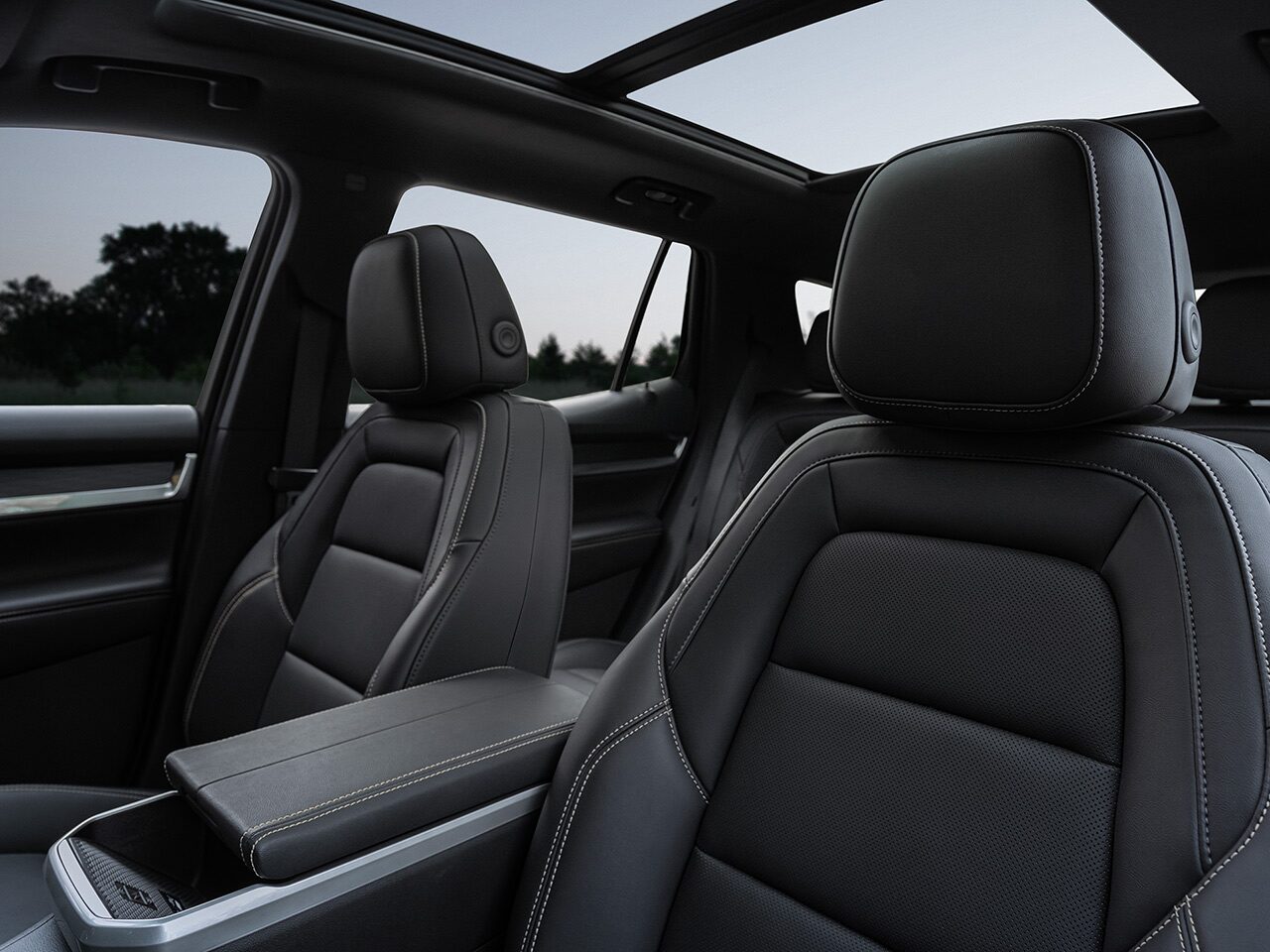 Interior View of a 2027 GMC Terrain Vehicle's Black Leather Front Passenger Seats with White Stitching and a Panoramic Sunroof.