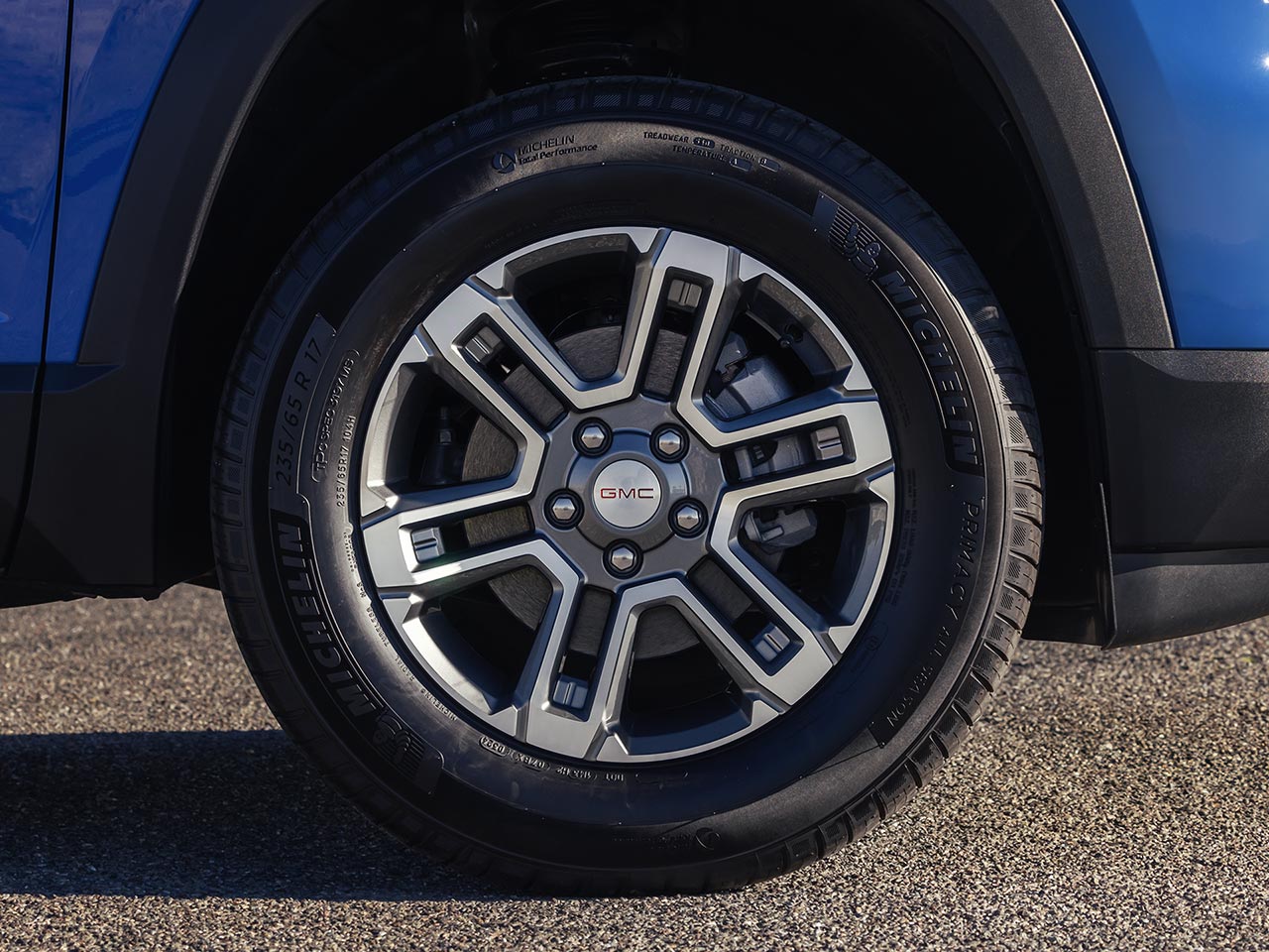 SUV bleu GMC Terrain 2027 avec une jante argentée et noire au premier plan.