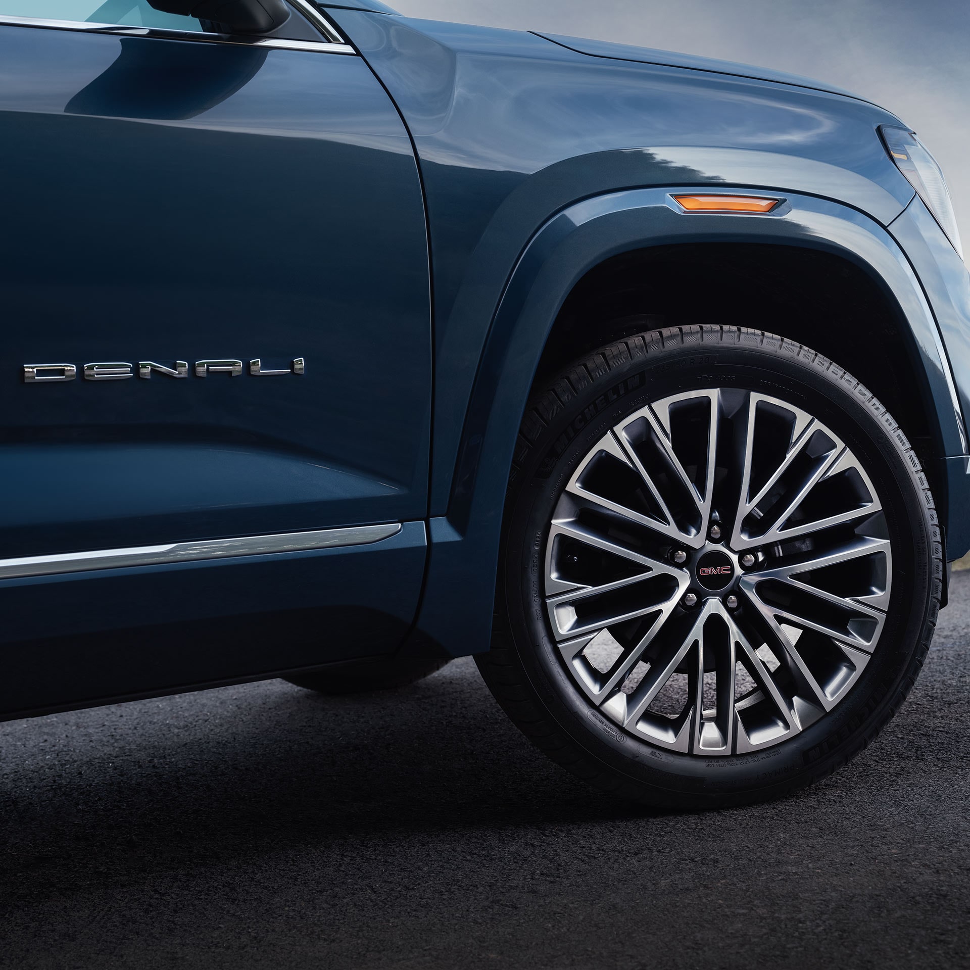 Vue latérale du SUV GMC Terrain Denali bleu foncé 2027, doté d’une jante à rayons multiples et du badge Denali.