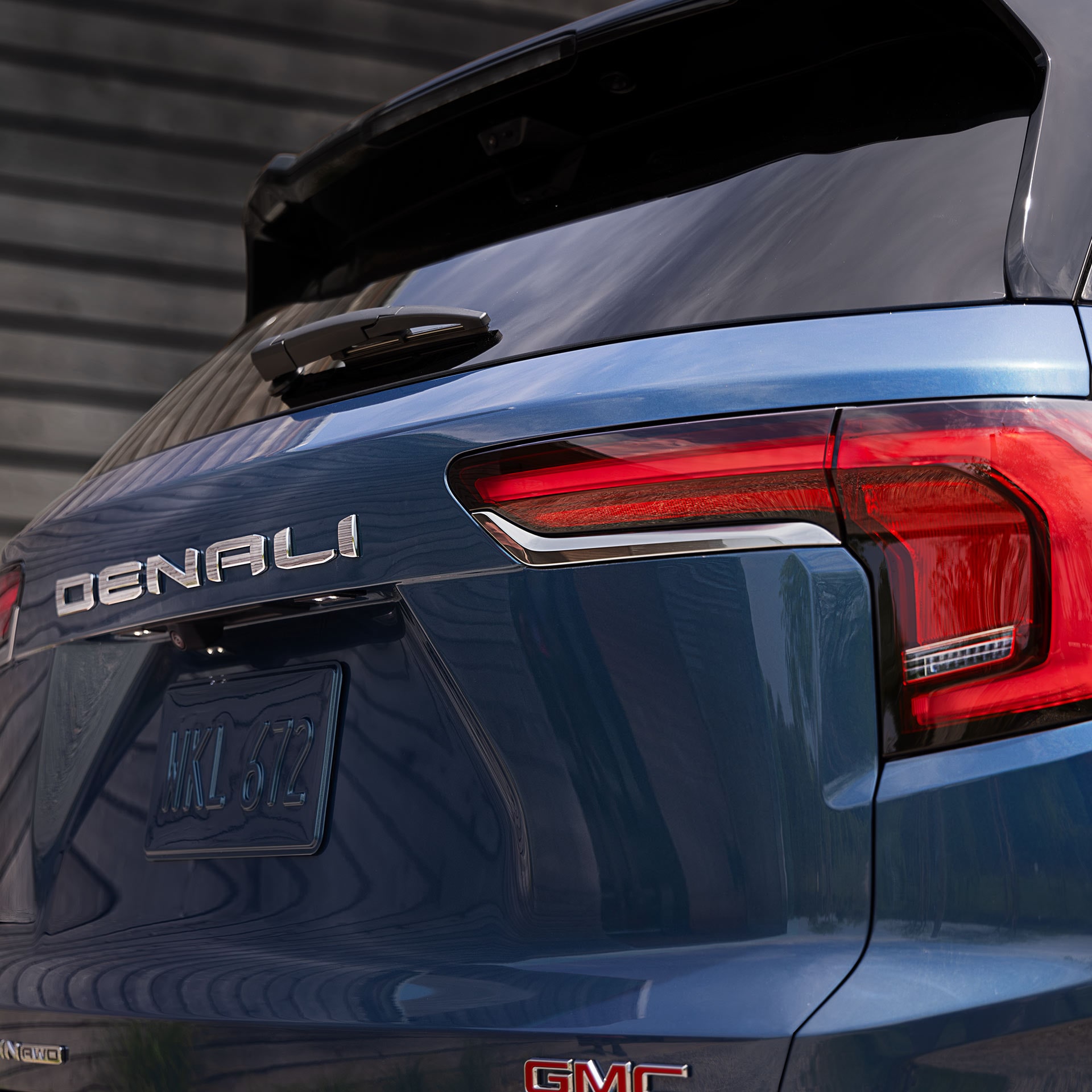 Vue rapprochée de l’arrière d’un SUV bleu GMC Terrain Denali 2027, avec le badge Denali et le feu arrière visibles.