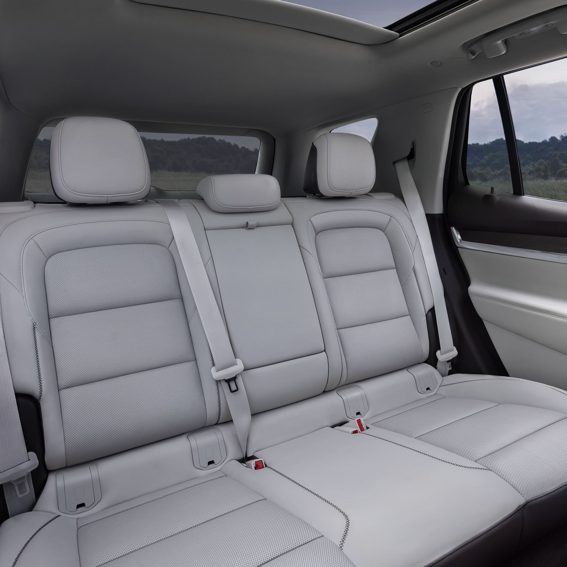 Les sièges arrière passager d’un GMC Terrain 2027 en cuir perforé gris clair et toit ouvrant panoramique.