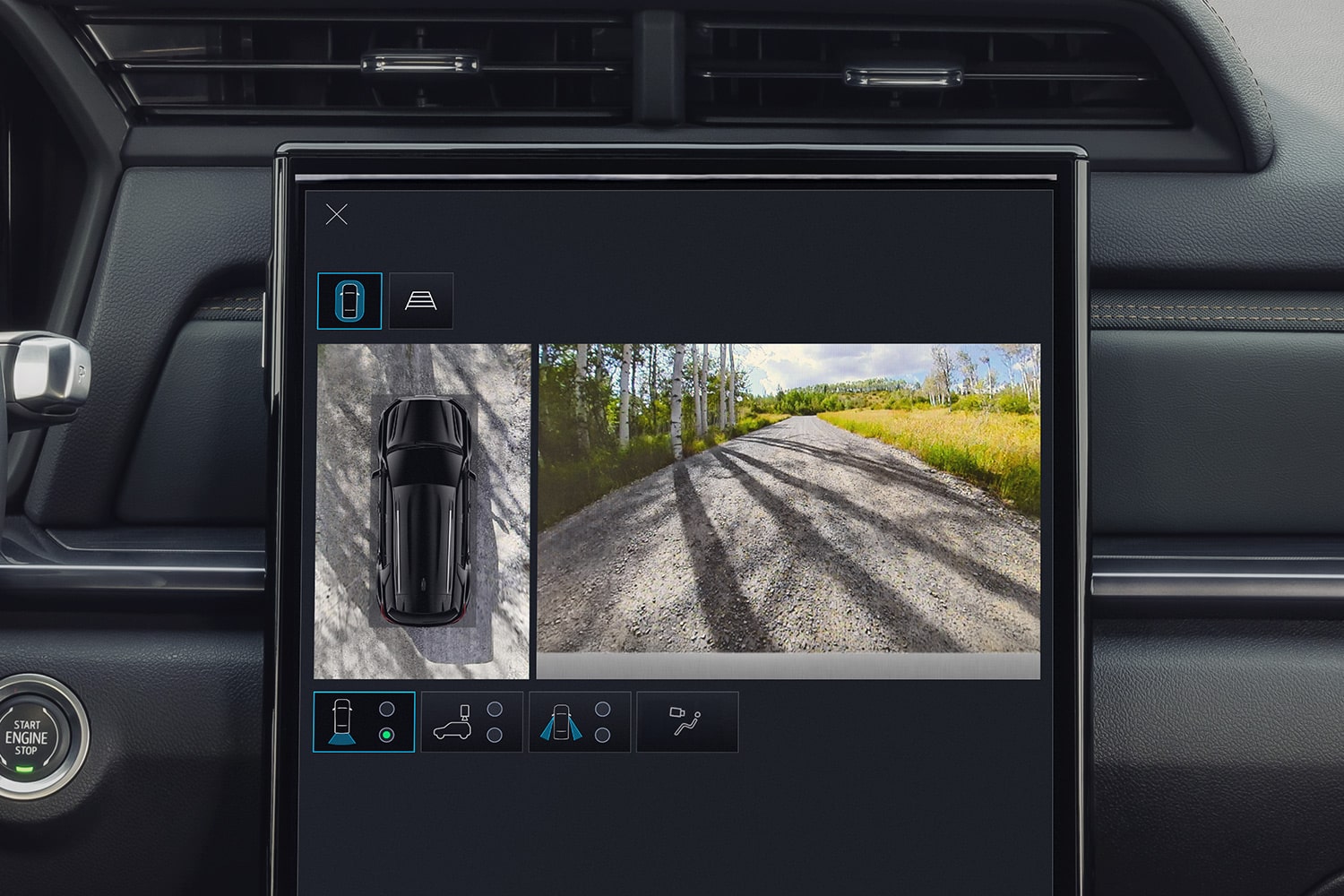 Écran d’infodivertissement GMC Terrain 2027 affichant une vue de caméra à 360 degrés du SUV et d’une route de gravier devant lui.