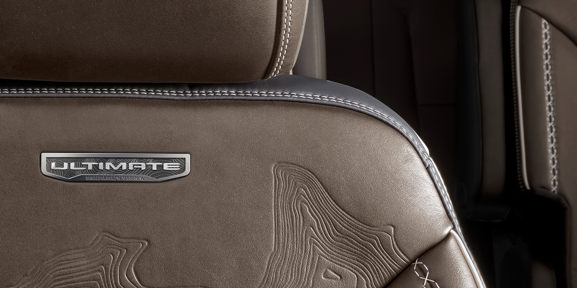  Vue rapprochée de l’emblème Denali sur les sièges d’un véhicule GMC Denali 2026.
