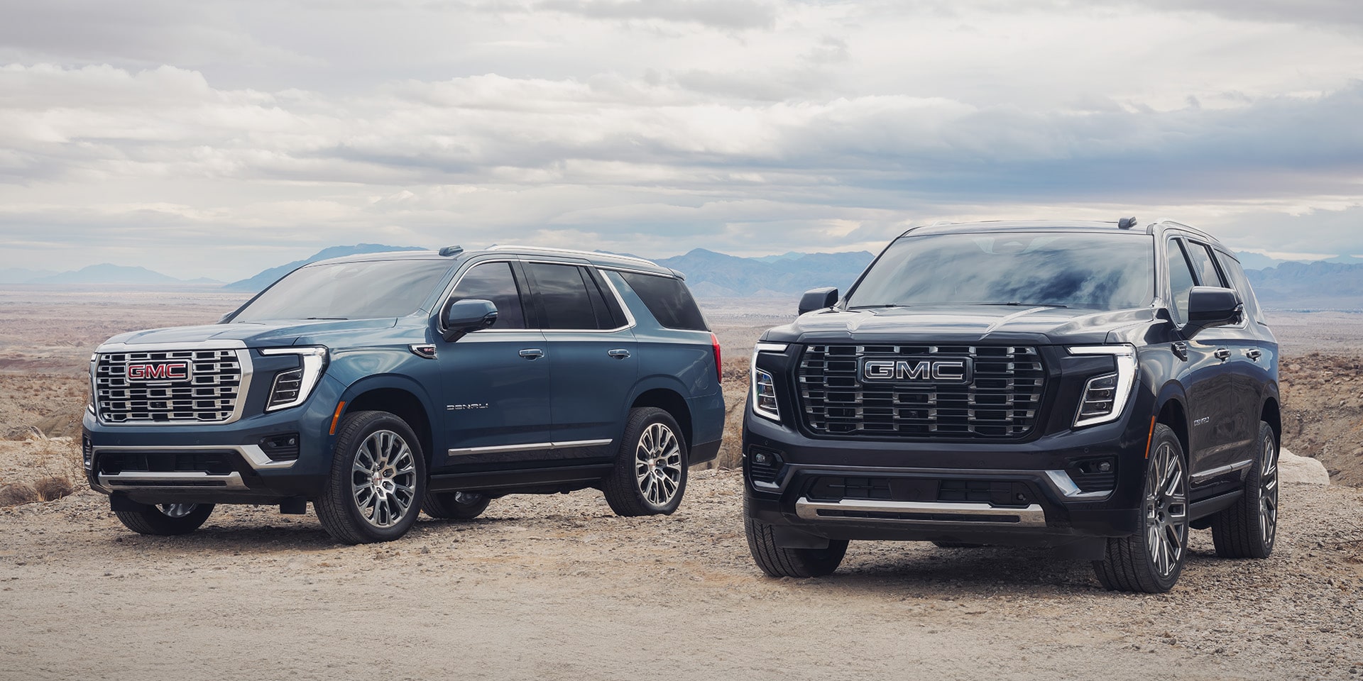Deux VUS GMC stationnés l’un à côté de l’autre à la plage.
