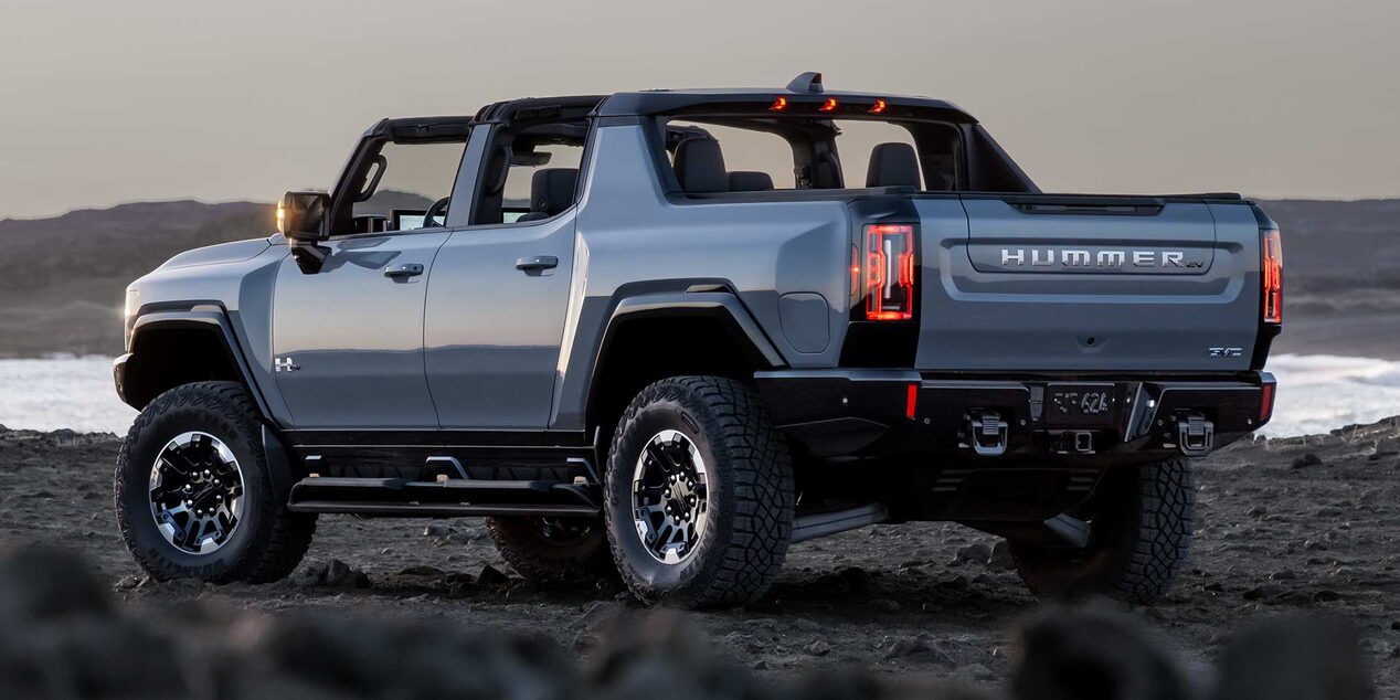 Back-side view of the GMC HUMMER EV Pickup Truck parked on a rough terrain.