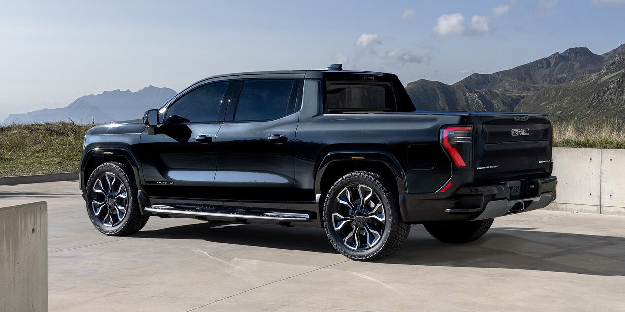 Vue latérale du GMC Sierra EV stationné dans une entrée par une journée ensoleillée.
