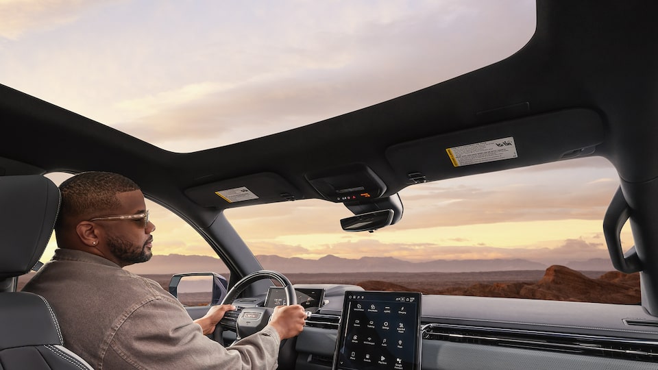 Le toit panoramique en verre fixe du GMC Sierra EV 2026 vu des sièges arrière.
