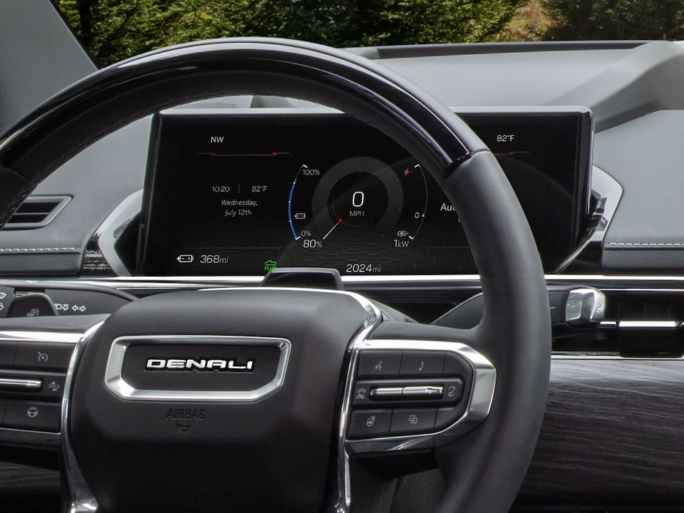 Vue rapprochée du centralisateur informatique de bord derrière le volant du pick-up GMC Sierra EV 2026.