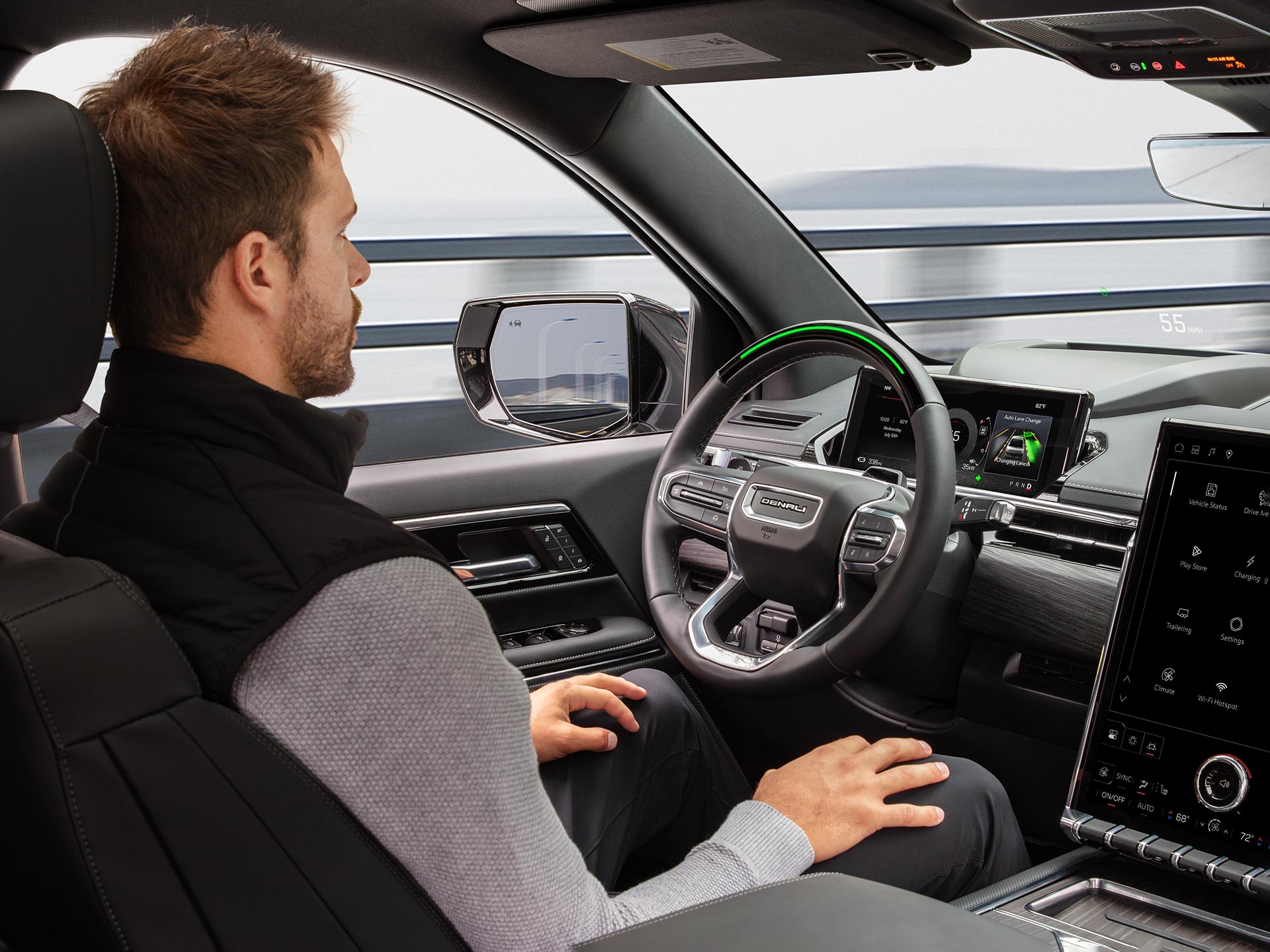 Une personne conduit le GMC Sierra EV 2026 sans les mains avec l’aide de la technologie Super Cruise.