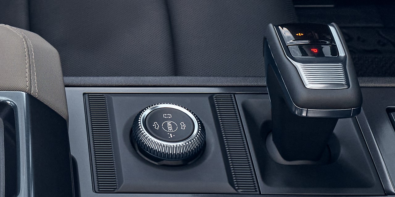 Vue rapprochée du bouton de modes de conduite et du levier de vitesses du VUS GMC Hummer EV 2026.