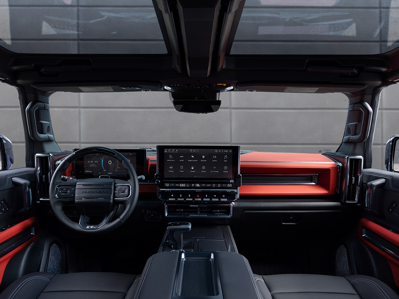 L’habitacle côté conducteur du VUS GMC Hummer EV 2026 en couleur braise vélocité vu des sièges arrière.