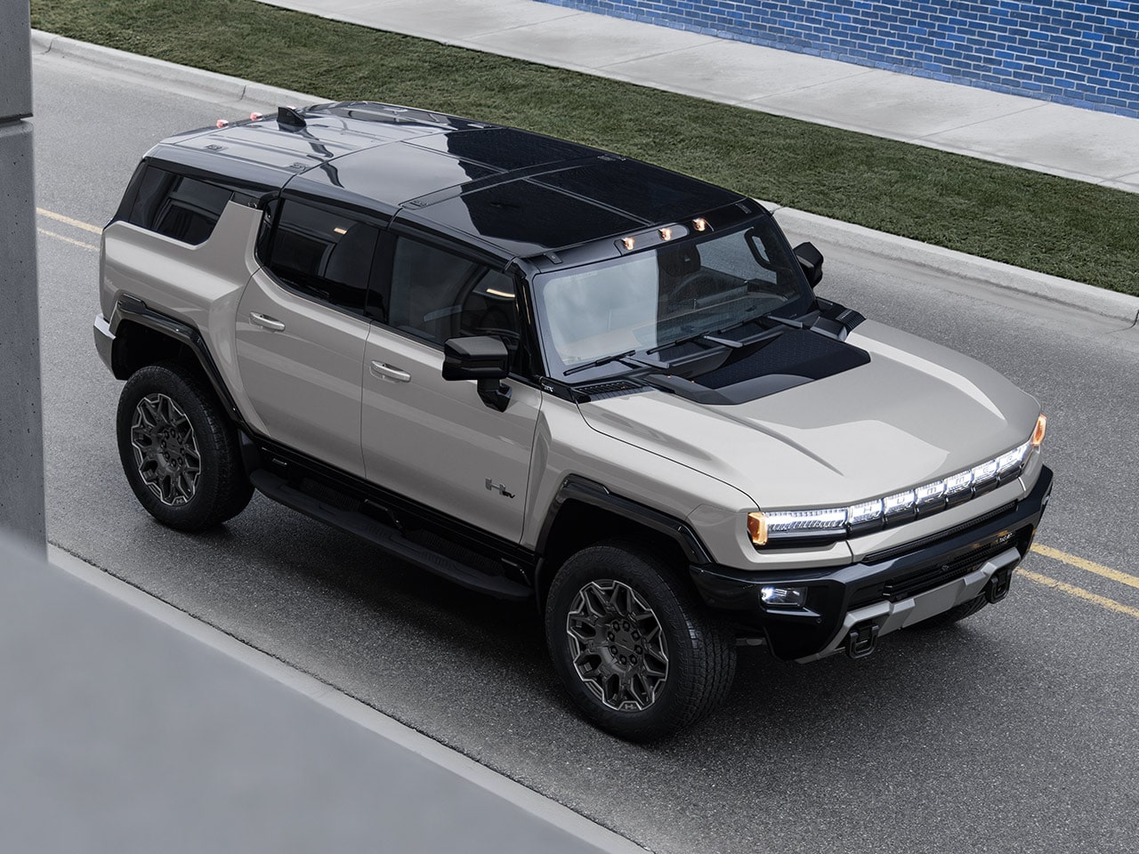 Vue latérale avant du VUS GMC Hummer EV 2026 en mouvement seul sur la route.