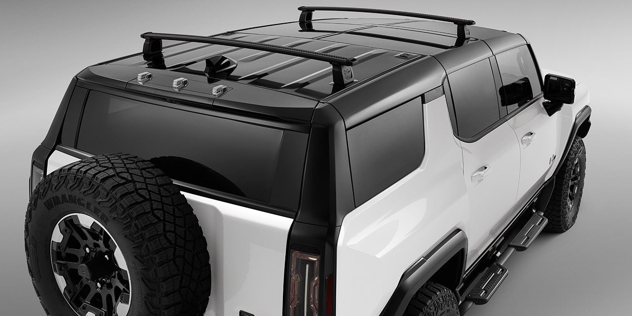 Vue arrière d’un VUS GMC Hummer EV 2026 personnalisé avec porte-bagages de toit.