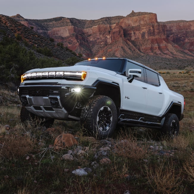 GMC Hummer EV truck on rough terrain.