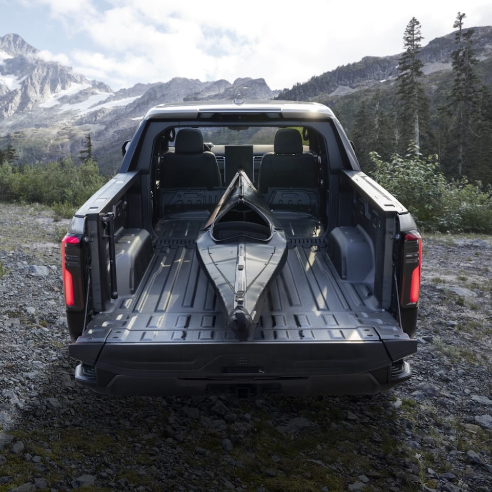 Back view of Sierra EV Denali Edition 1 loaded with a kayak in its cargo bed.