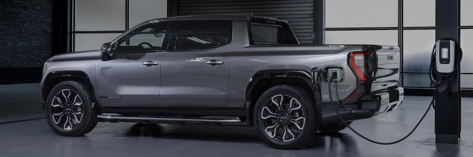 Front-side view of the 2025 GMC Sierra EV Denali being EV charged.