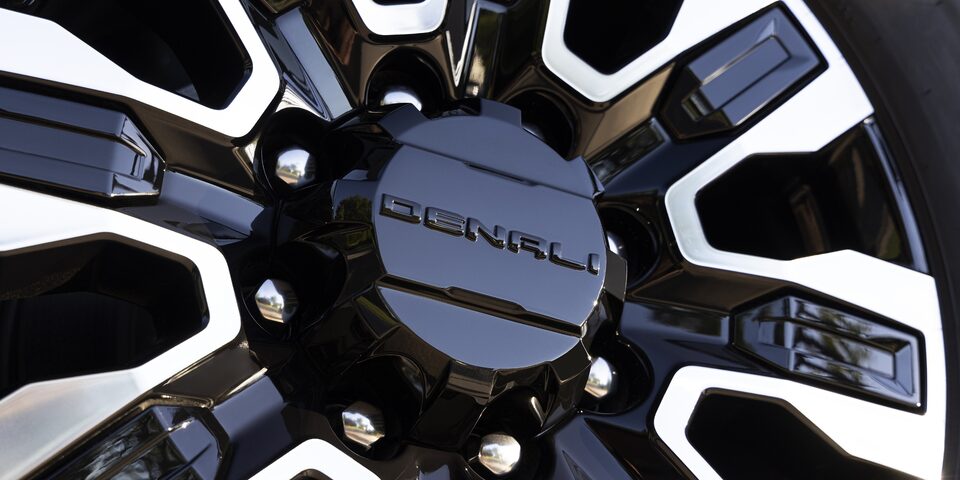 Close-up of 2024 Sierra HD Denali Ultimate exclusive 20-inch aluminum wheel with high-gloss black accents.