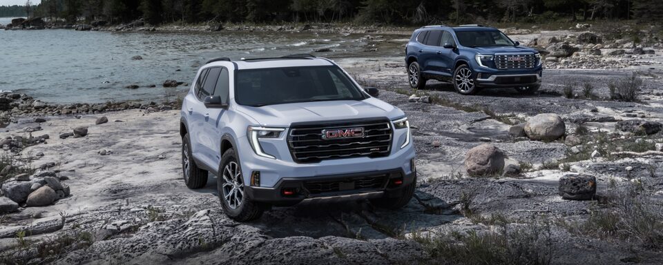 Deux modèles GMC Acadia 2024 stationnés au bord d’un lac.