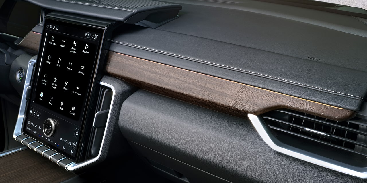 Vue rapprochée des boiseries haut de gamme du tableau de bord du GMC Acadia Denali Ultimate 2026.
