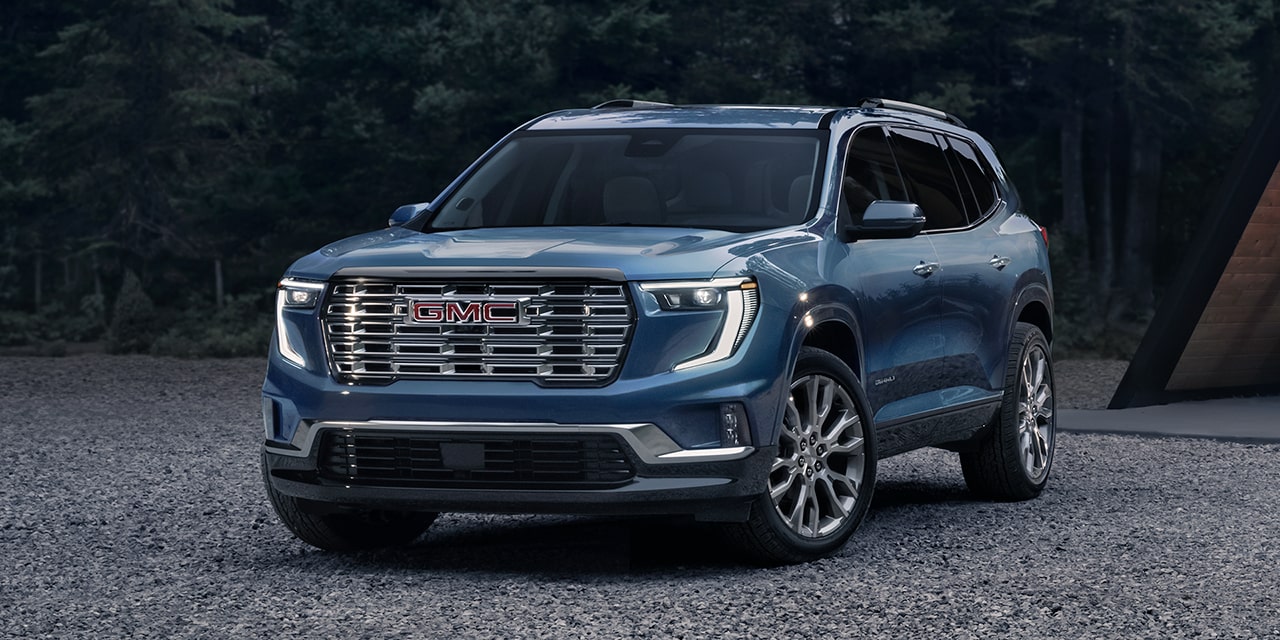 GMC Acadia Denali Ultimate 2026 stationné près d’une forêt.