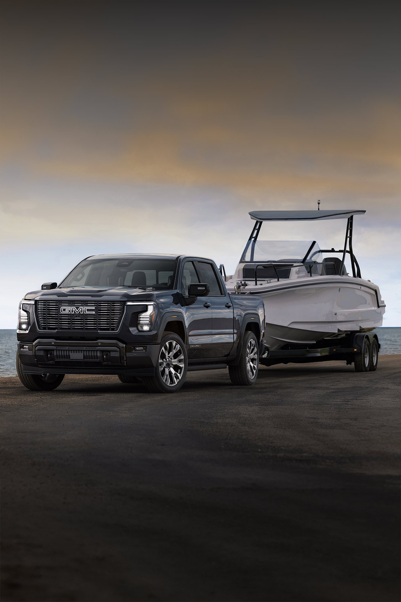 Un GMC Sierra 1500 2027 de nouvelle génération remorquant un bateau près de la plage.