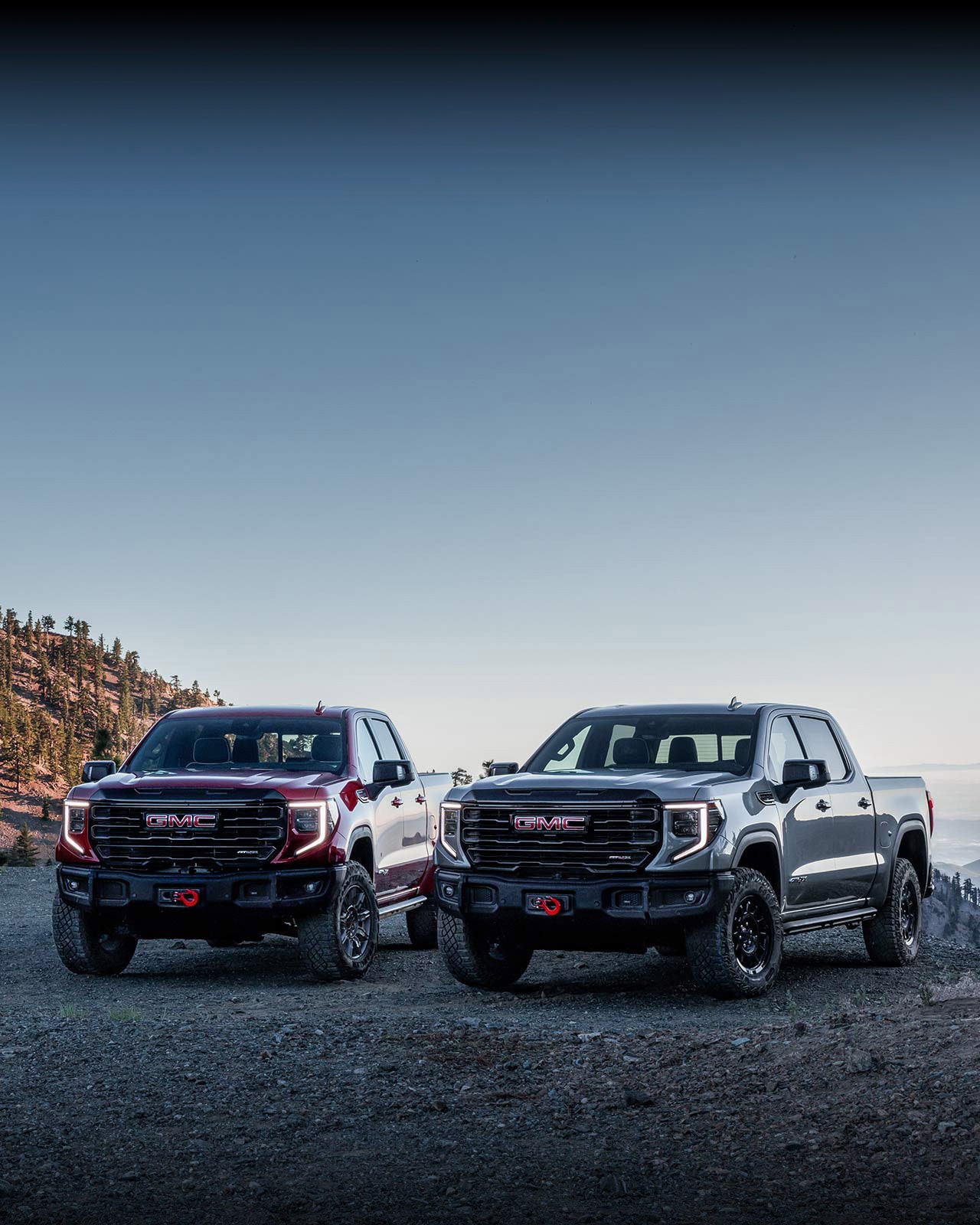 Deux camions GMC Sierra 1500 2027 de nouvelle génération stationnés sur une falaise.