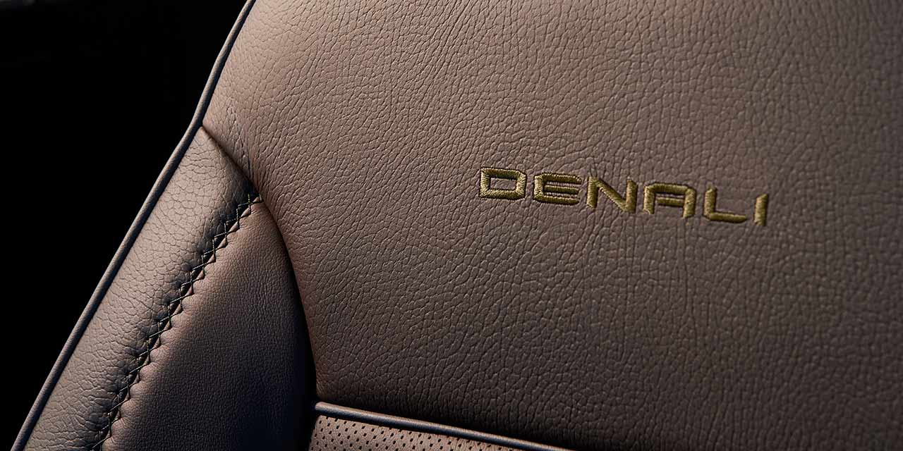 Broderie Denali dorée sur le siège en cuir brun d’un GMC Sierra HD.