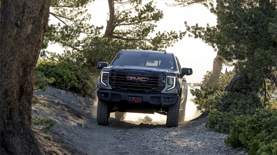 Front view of the 2023 GMC Sierra AT4X AEV Edition driving outdoors.