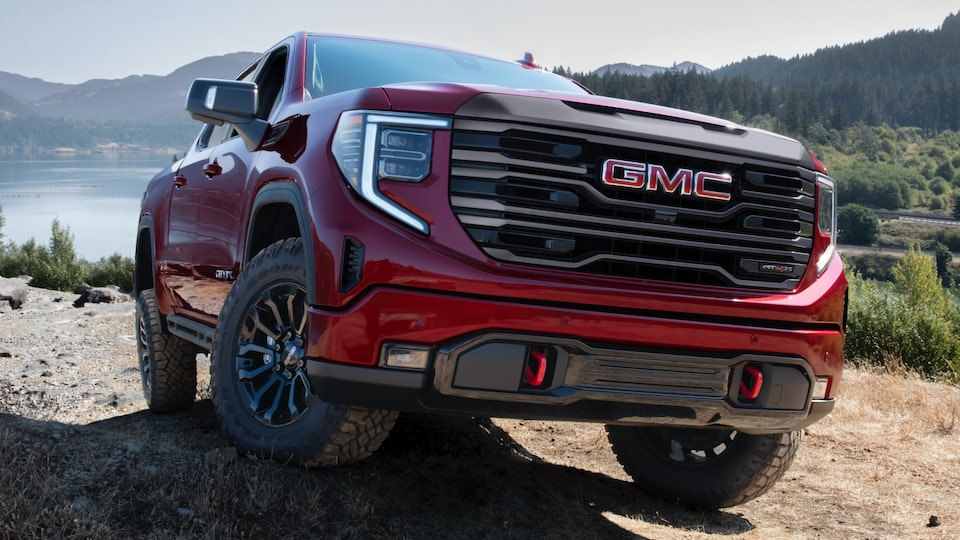 2022 GMC Sierra AT4X driving outdoors featuring the grille.