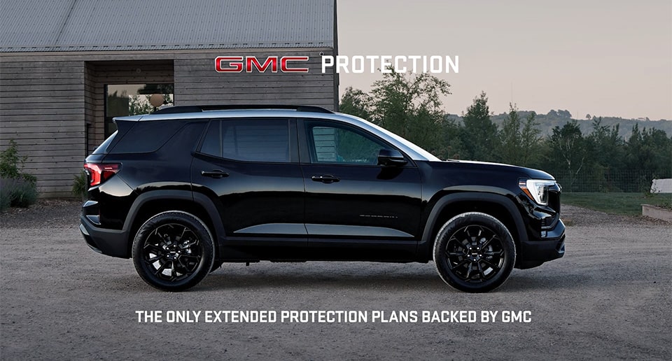 GMC Truck Driving on a Road by a Lake