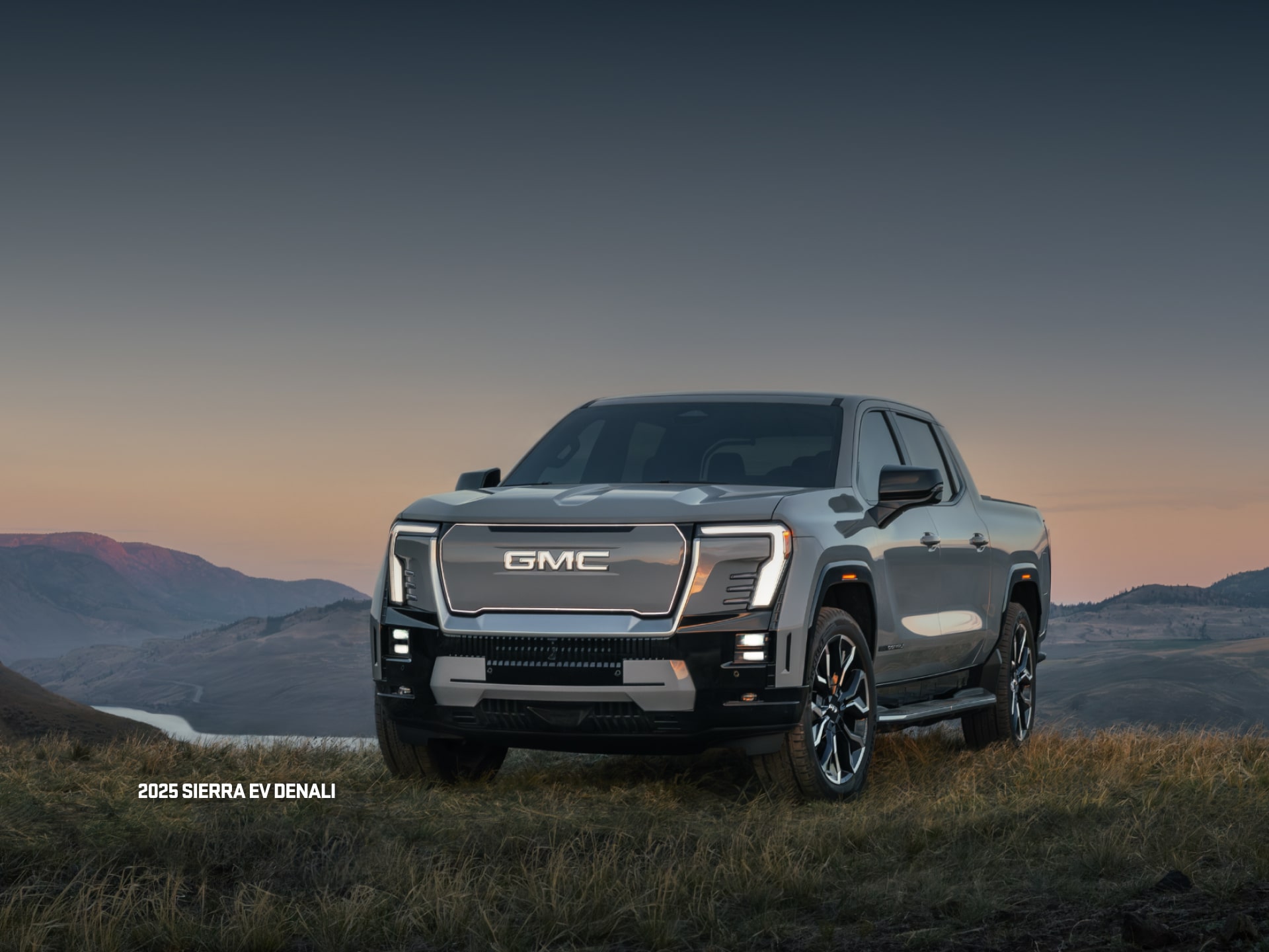 Vue latérale avant du VUS GMC Hummer EV 2026 en mouvement seul sur la route.