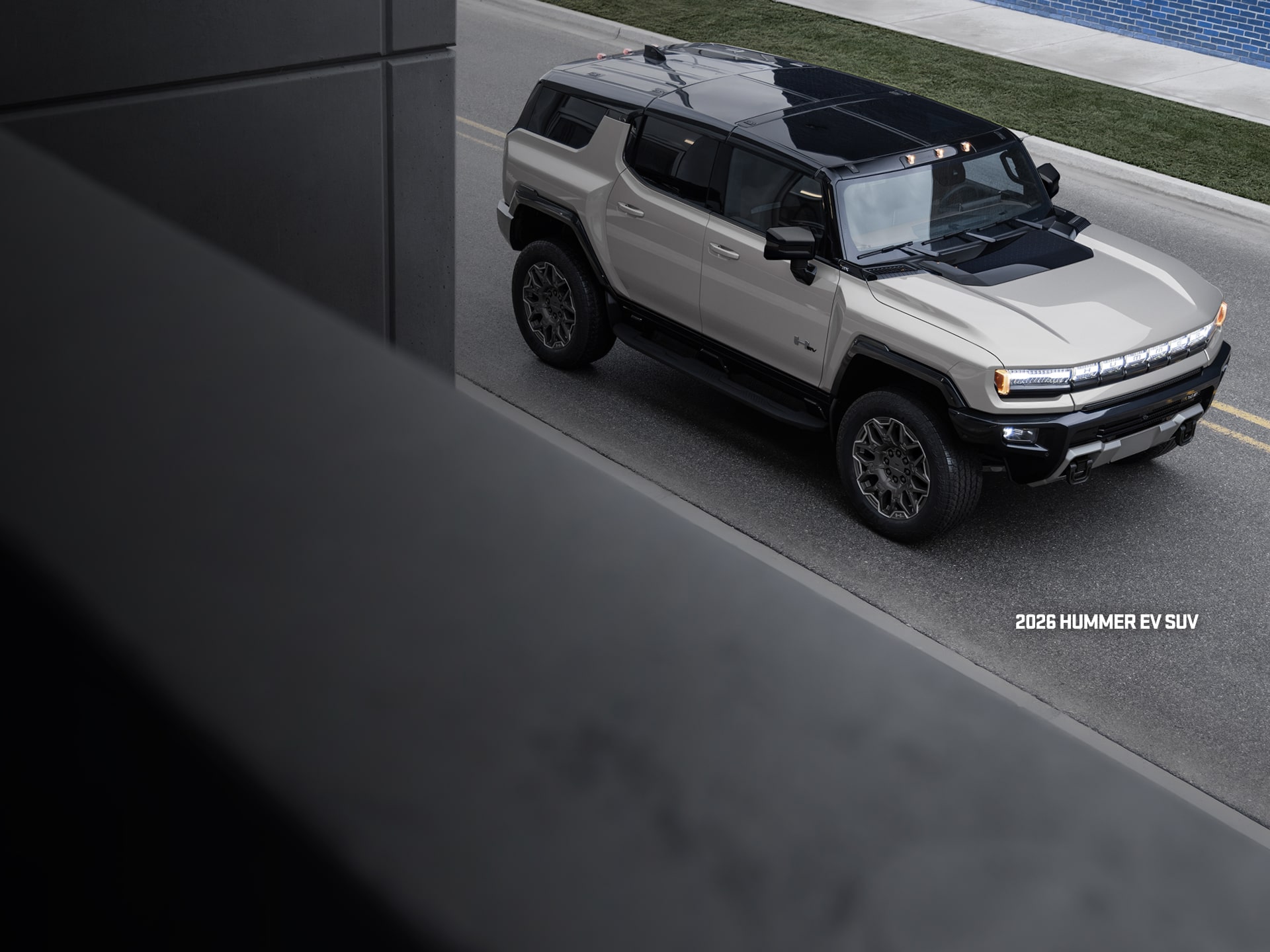 Front-Side View of the 2026 GMC Hummer EV SUV Driving on a Road alone.