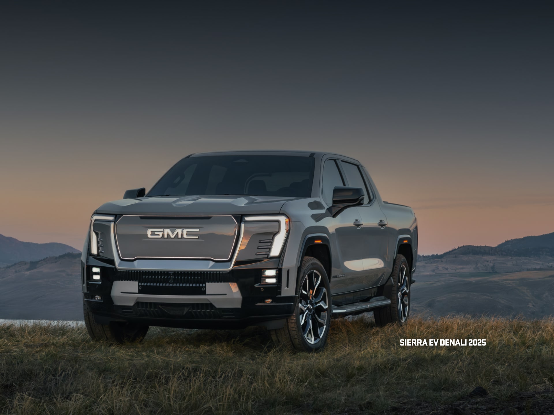 Vue latérale avant du VUS GMC Hummer EV 2026 en mouvement seul sur la route.