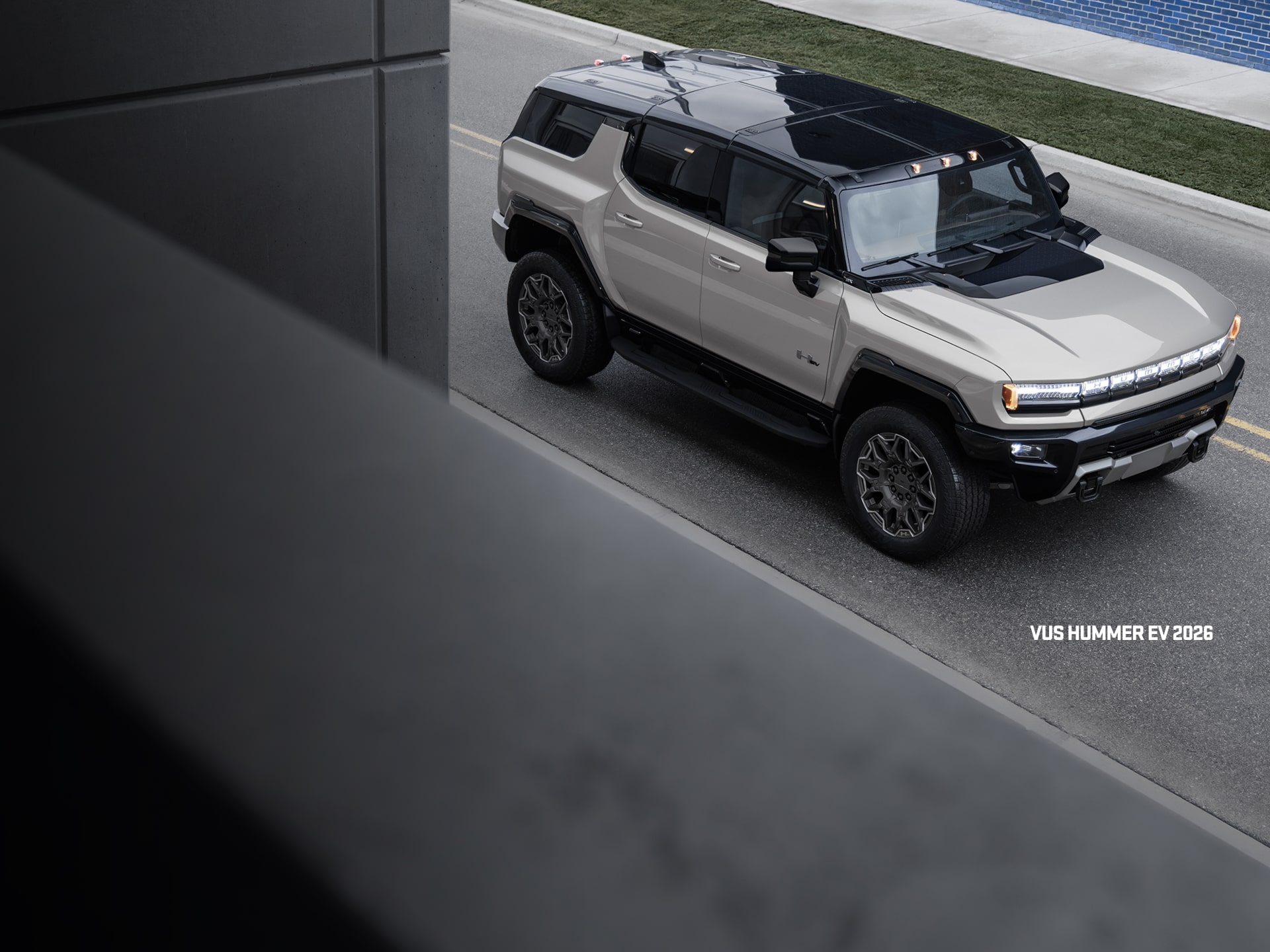 Vue latérale avant du VUS GMC Hummer EV 2026 en mouvement seul sur la route.