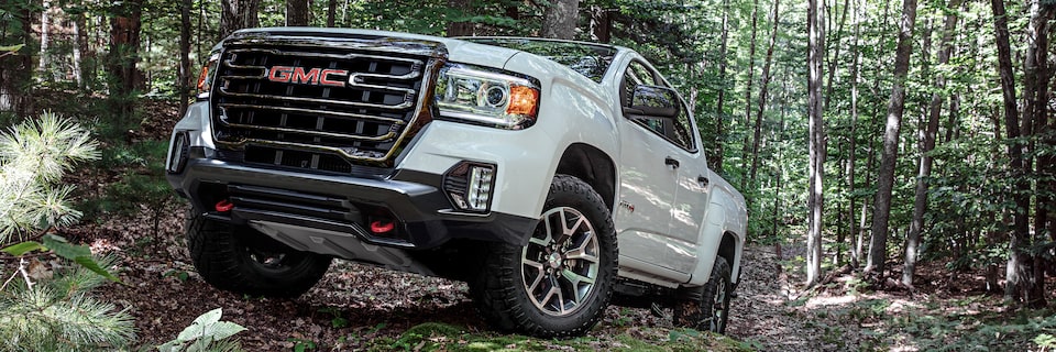 2021 GMC Canyon AT4 driving in a wooded area.