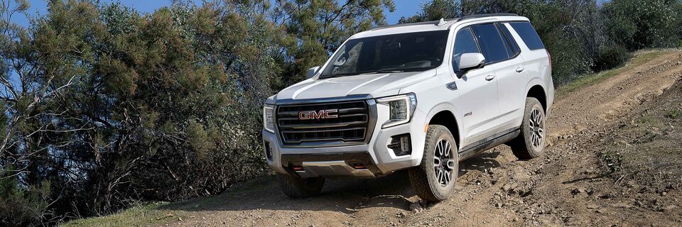 Front side view of the 2021 GMC Yukon AT4 driving downhill.