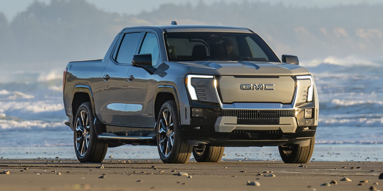 Front-side view of the Sierra EV Pickup Truck parked alone on the beach.