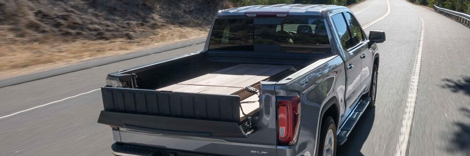 Rear-view of the 2022 GMC Sierra 1500 driving on the road.