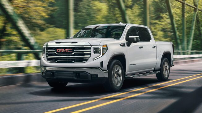 Side view profile of the 2023 Sierra 1500 driving on the road.