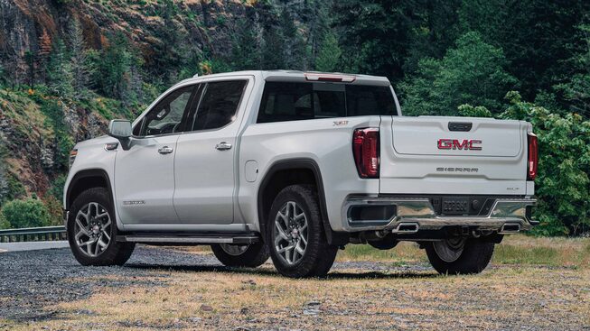 Exterior driver side view of the 2023 GMC Sierra 1500 parked beside a road.