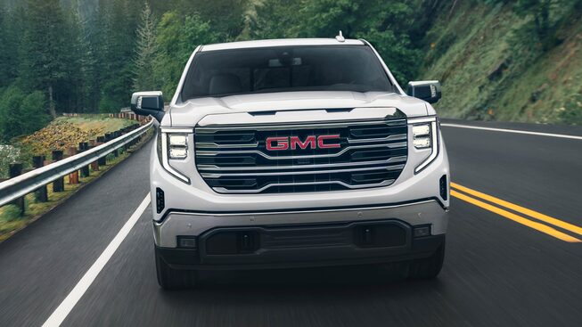 2023 Sierra 1500 front view driving on the road.