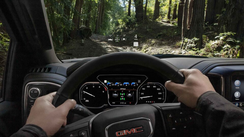 Homme qui tient le volant d’un Sierra HD AT4 2023.