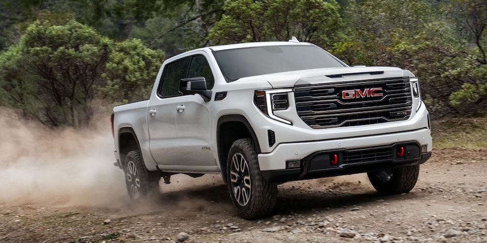 The 2024 GMC Sierra 1500 AT4 skidding on a dusty road.