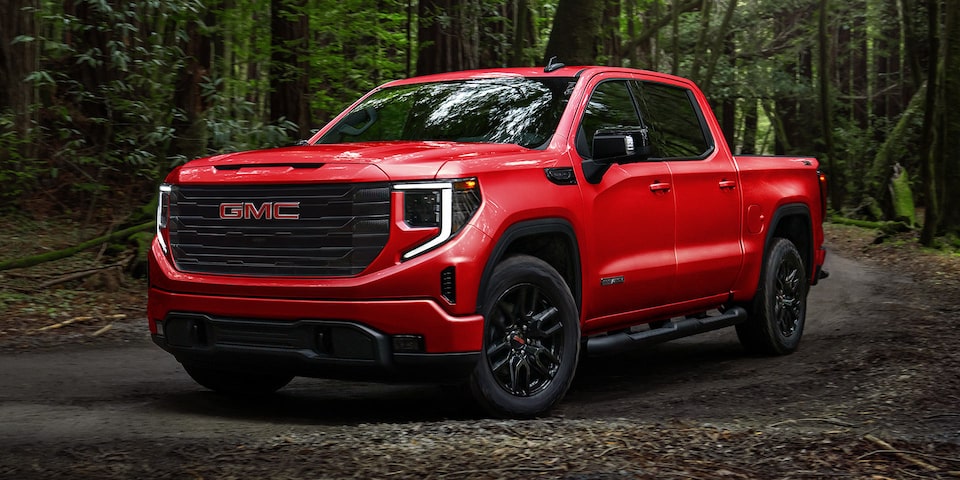 Le GMC Sierra 1500 SLE 2024 édition Élévation stationné dans un champ à côté d’une colline.