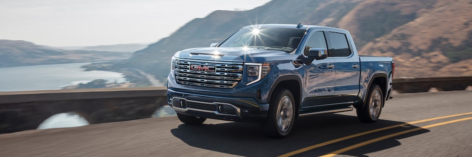 Le GMC Sierra 1500 Denali Ultimate 2024 en mouvement sur une route au bord de la mer.