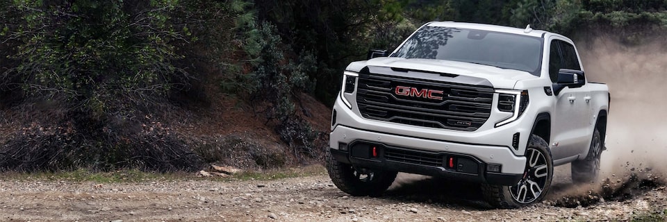 Vue avant du GMC Sierra HD AT4 2024 en conduite tout-terrain.
