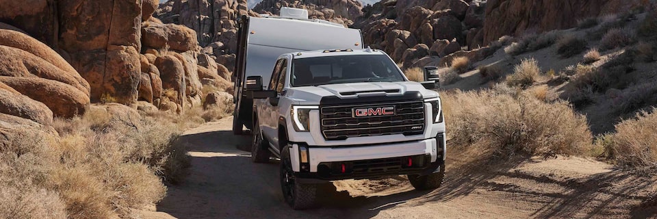 Le GMC Sierra AT4 2024 en remorque sur un terrain rocailleux.