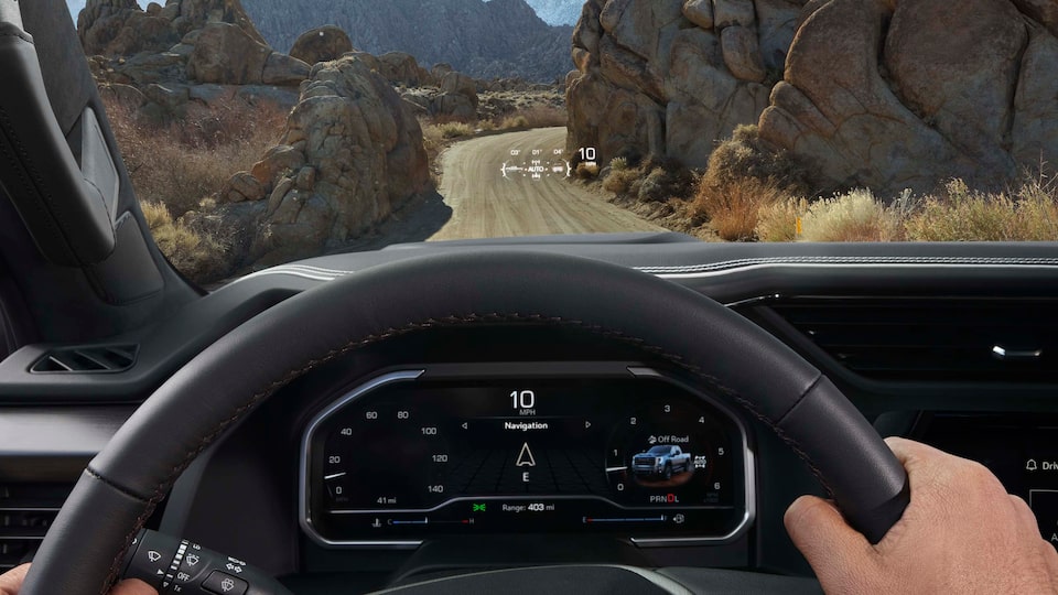 Homme qui tient le volant d’un Sierra HD AT4 2024.