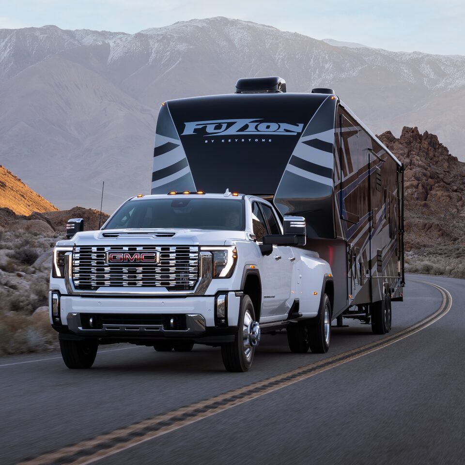 The 2024 GMC Sierra HD towing a large trailer.